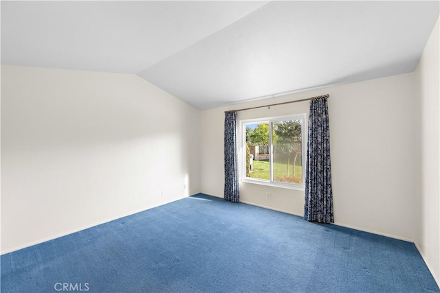 carpeted spare room with lofted ceiling