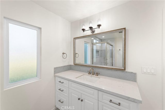 bathroom with a shower with shower door and vanity