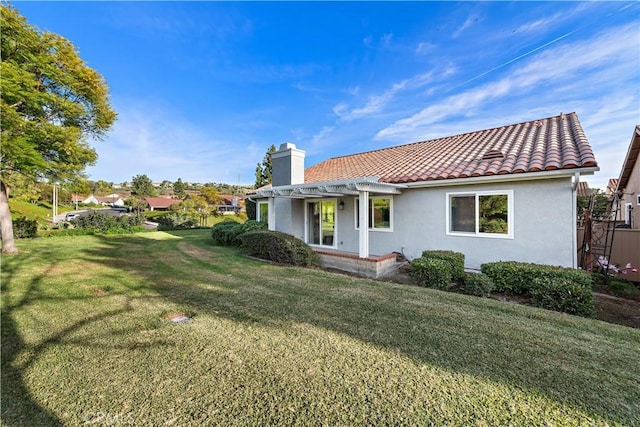 back of house featuring a lawn and a pergola