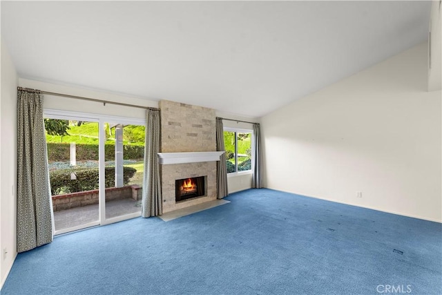 unfurnished living room with vaulted ceiling, carpet flooring, and a fireplace