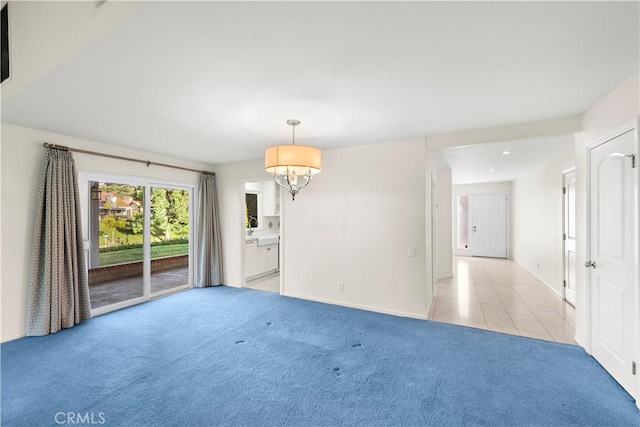 carpeted empty room with a chandelier