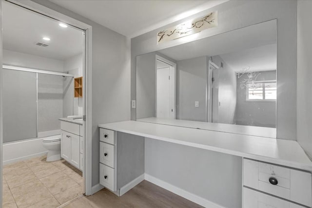 full bathroom featuring toilet, vanity, and shower / bath combination with glass door