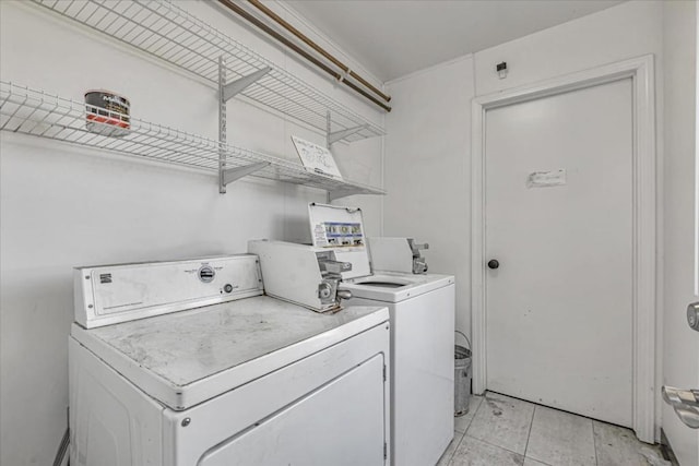 clothes washing area with light tile patterned floors and independent washer and dryer