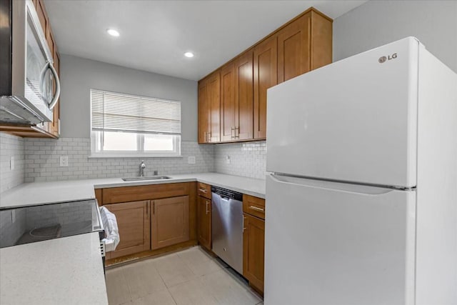 kitchen featuring sink, backsplash, light tile patterned floors, and stainless steel appliances