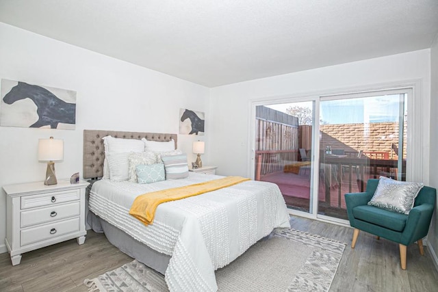 bedroom with access to exterior and light hardwood / wood-style flooring