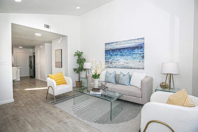 living room featuring hardwood / wood-style floors and high vaulted ceiling