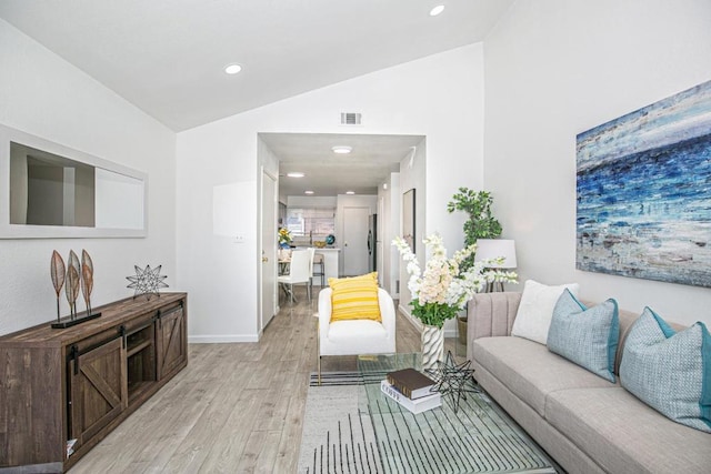 living room featuring vaulted ceiling and light wood-type flooring