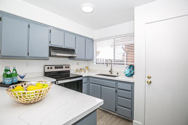 kitchen with stainless steel electric stove, sink, and light hardwood / wood-style floors