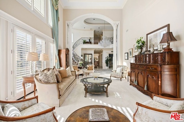 living area with light carpet, a high ceiling, ornamental molding, and a raised ceiling