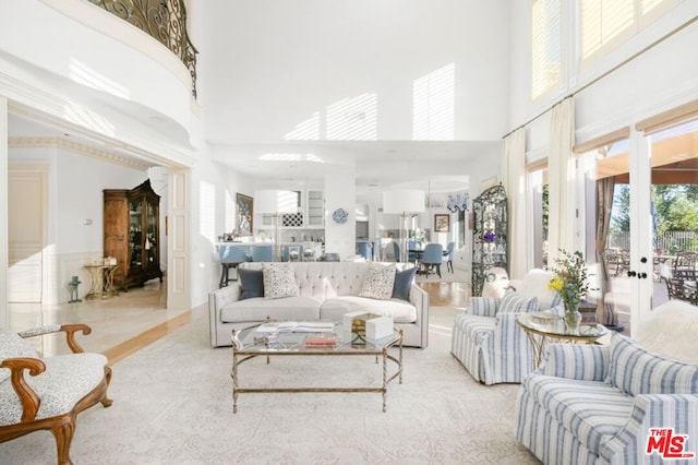 living room with a towering ceiling and french doors