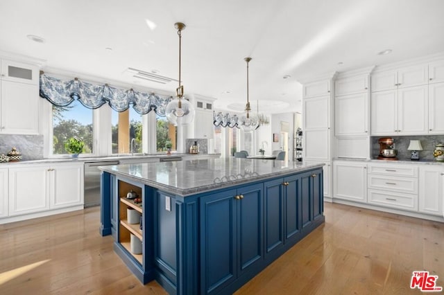 kitchen with white cabinetry, blue cabinetry, a kitchen island, and decorative light fixtures