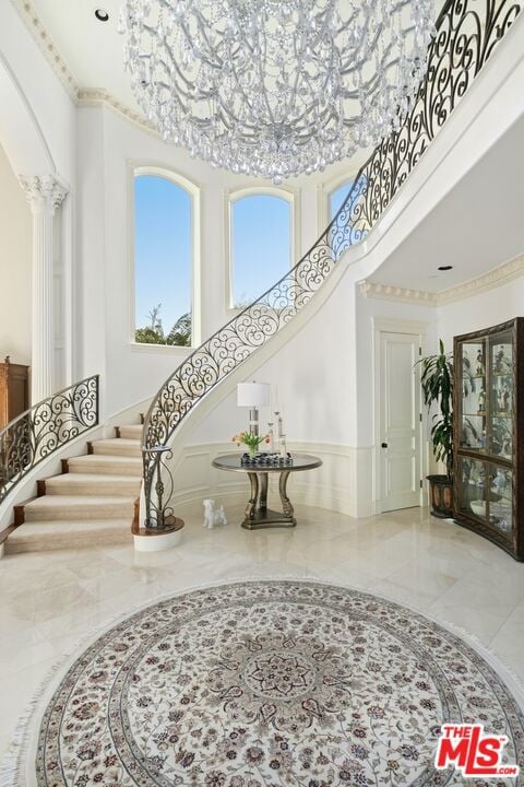 foyer featuring a towering ceiling and ornate columns