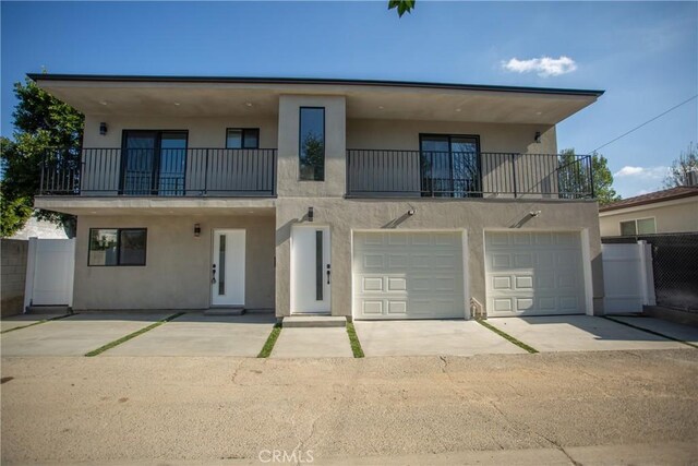 view of front of property featuring a balcony and a garage