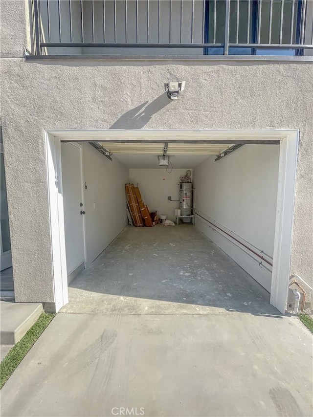 garage featuring water heater, driveway, and a garage door opener