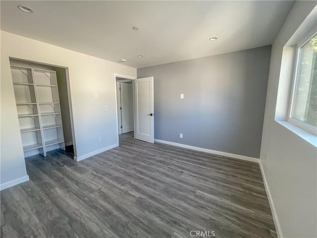 unfurnished bedroom featuring dark wood-style floors, baseboards, and recessed lighting