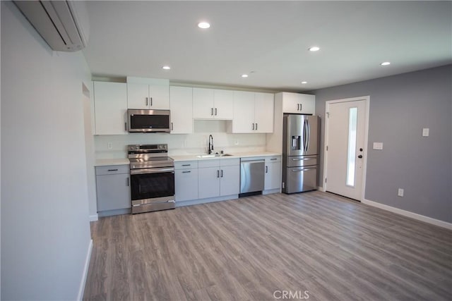 kitchen featuring light countertops, appliances with stainless steel finishes, a sink, and white cabinets