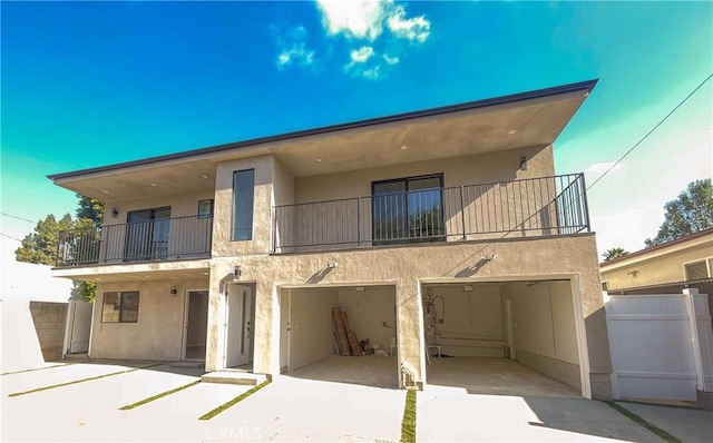 exterior space with a balcony, a garage, and stucco siding