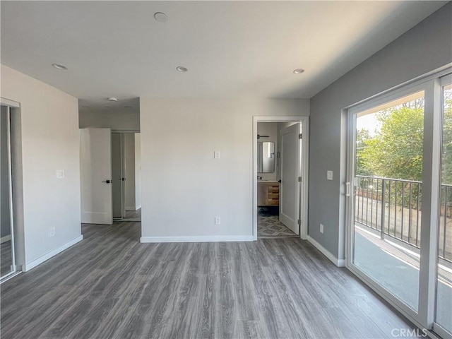 interior space with access to exterior, baseboards, and wood finished floors