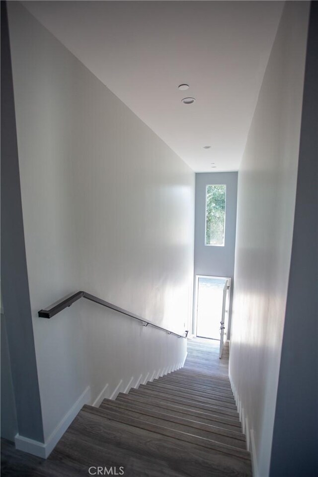 stairway featuring wood finished floors and baseboards