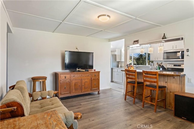 kitchen featuring dark wood-type flooring, a breakfast bar, appliances with stainless steel finishes, and kitchen peninsula