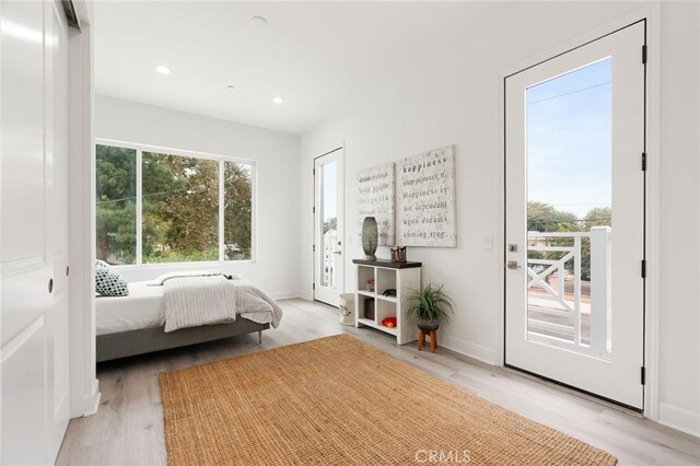 bedroom featuring access to exterior and light hardwood / wood-style flooring