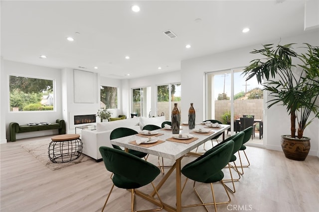 dining room featuring a fireplace and light hardwood / wood-style flooring