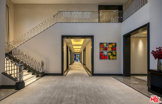 interior space with carpet floors and a towering ceiling