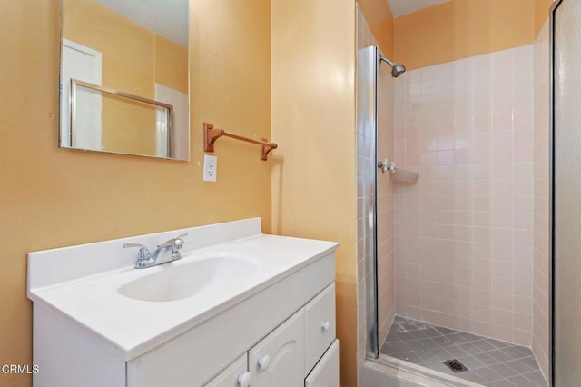 bathroom with tiled shower and vanity