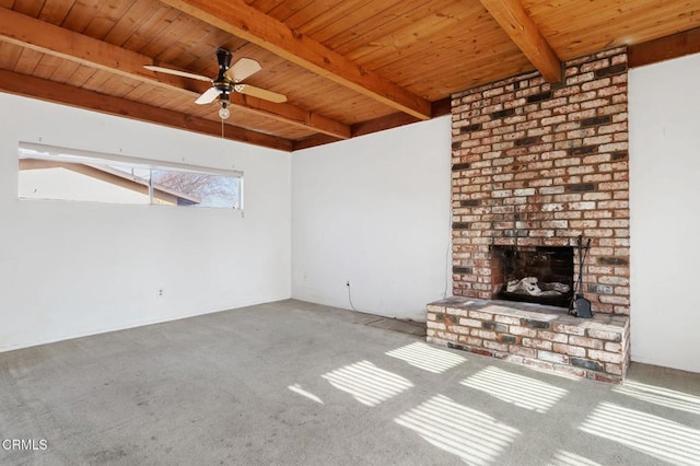 unfurnished living room with carpet, beamed ceiling, ceiling fan, a brick fireplace, and wooden ceiling