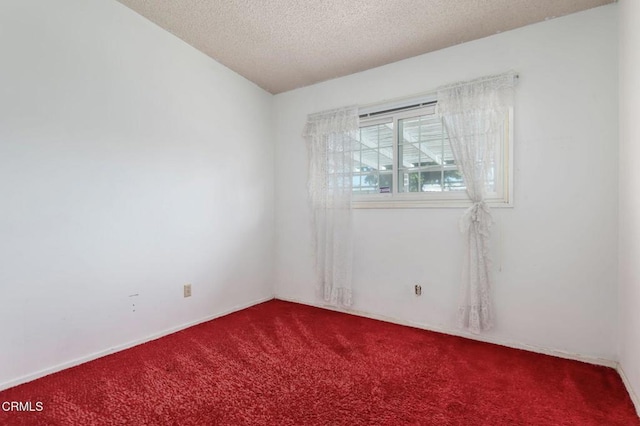 carpeted spare room with a textured ceiling