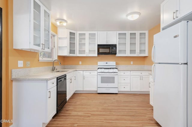 kitchen with light hardwood / wood-style floors, sink, white cabinetry, and black appliances