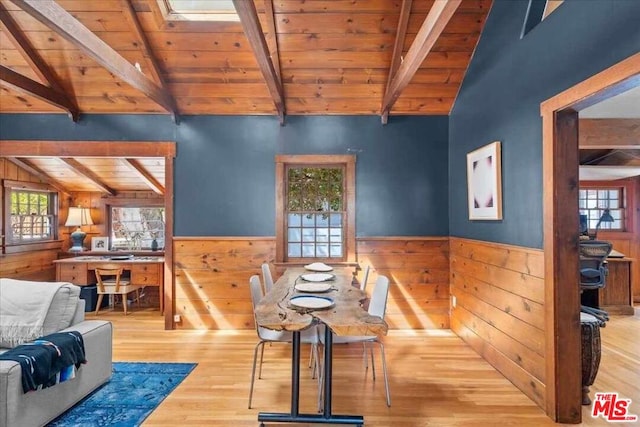 dining area with light wood-type flooring, wood ceiling, and vaulted ceiling with beams