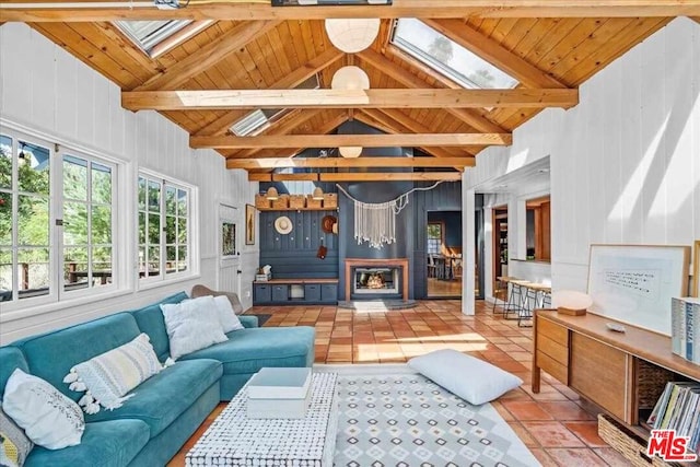 tiled living room with wooden ceiling, vaulted ceiling with skylight, and wooden walls