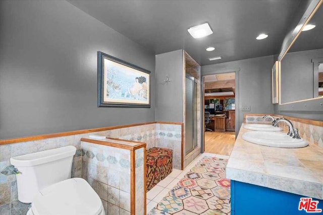 bathroom with toilet, tile patterned flooring, an enclosed shower, and vanity