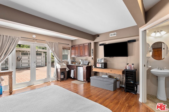 bedroom featuring french doors, sink, access to exterior, and light hardwood / wood-style flooring