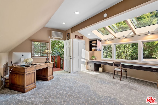 office area with lofted ceiling with skylight, carpet floors, and built in desk