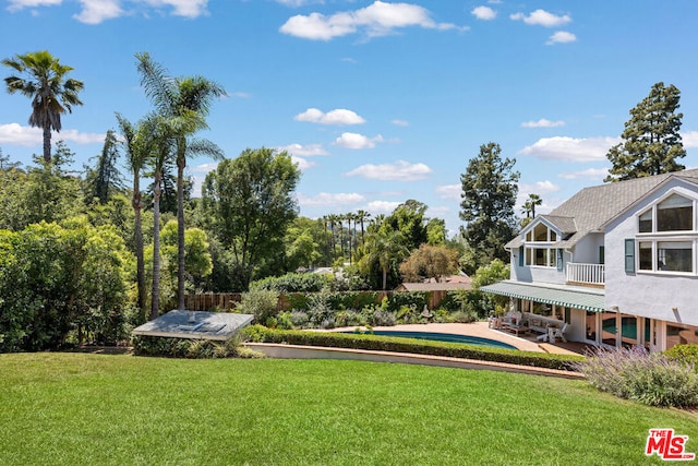 view of home's community featuring a swimming pool, a patio area, and a lawn