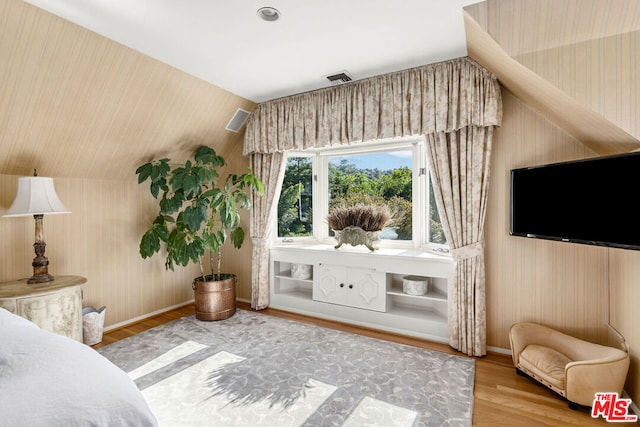 bedroom with lofted ceiling and wood-type flooring