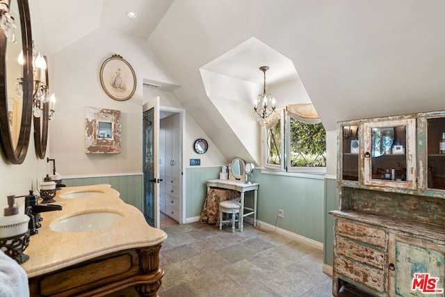 bathroom featuring lofted ceiling, a chandelier, and vanity