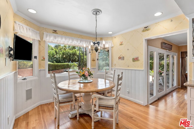 dining area with an inviting chandelier, crown molding, and light hardwood / wood-style floors