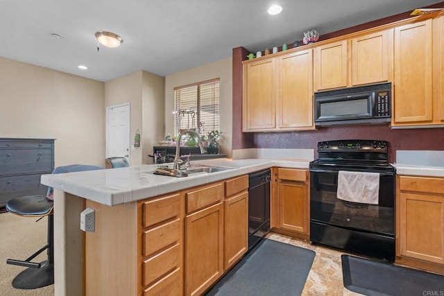 kitchen with tile countertops, a kitchen bar, kitchen peninsula, black appliances, and sink