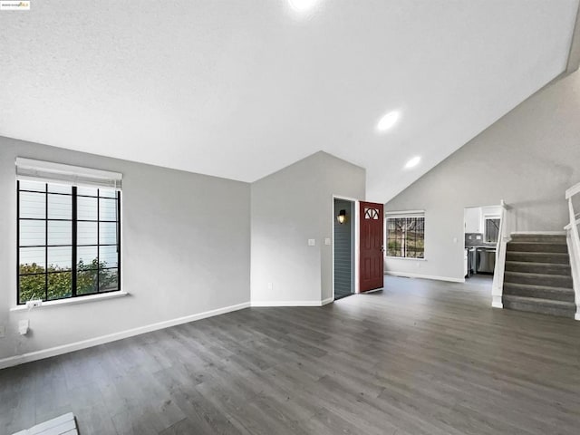 unfurnished living room with high vaulted ceiling and dark hardwood / wood-style flooring