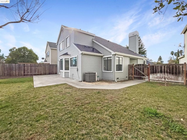 rear view of property featuring a patio area, central AC, and a yard