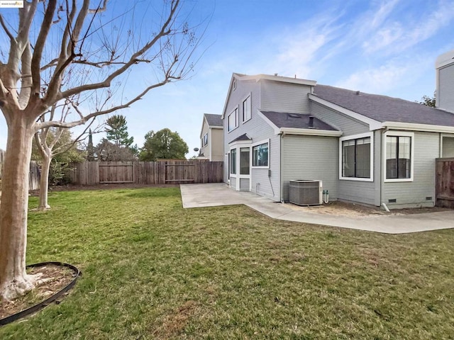 rear view of property featuring cooling unit, a lawn, and a patio