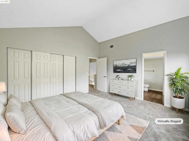 bedroom with vaulted ceiling, a closet, ensuite bath, and carpet