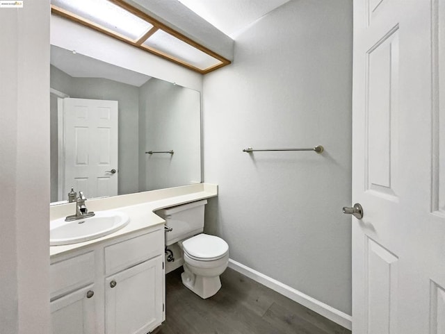 bathroom with hardwood / wood-style floors, toilet, and vanity