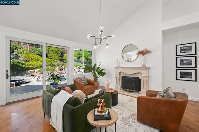 living room featuring high vaulted ceiling, hardwood / wood-style floors, and a notable chandelier