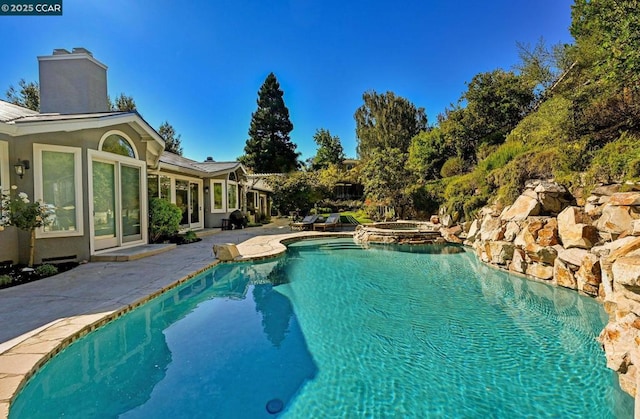 view of swimming pool with an in ground hot tub and a patio area