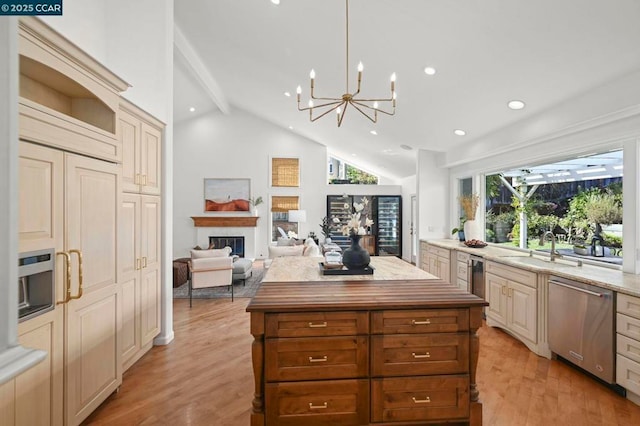 kitchen featuring dishwasher, hanging light fixtures, lofted ceiling with beams, light stone countertops, and a kitchen island