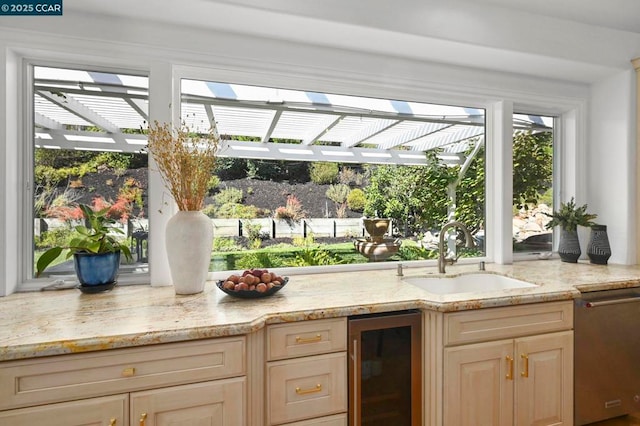 kitchen featuring wine cooler, sink, light brown cabinets, dishwasher, and light stone countertops